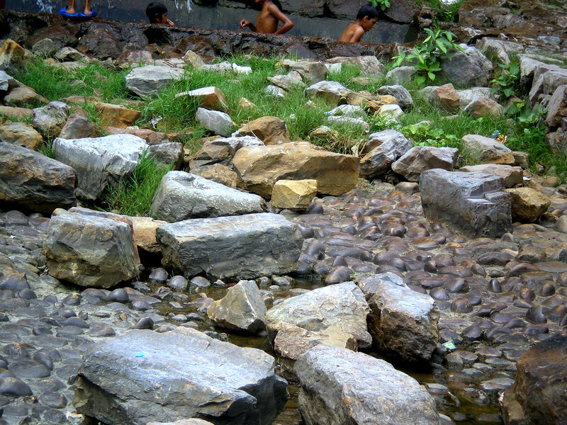 Children bathing in a rocky stream