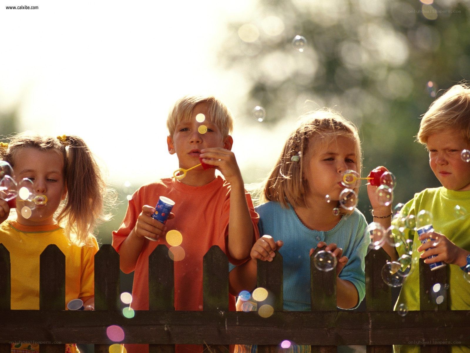 children blowing bubbles outdoors