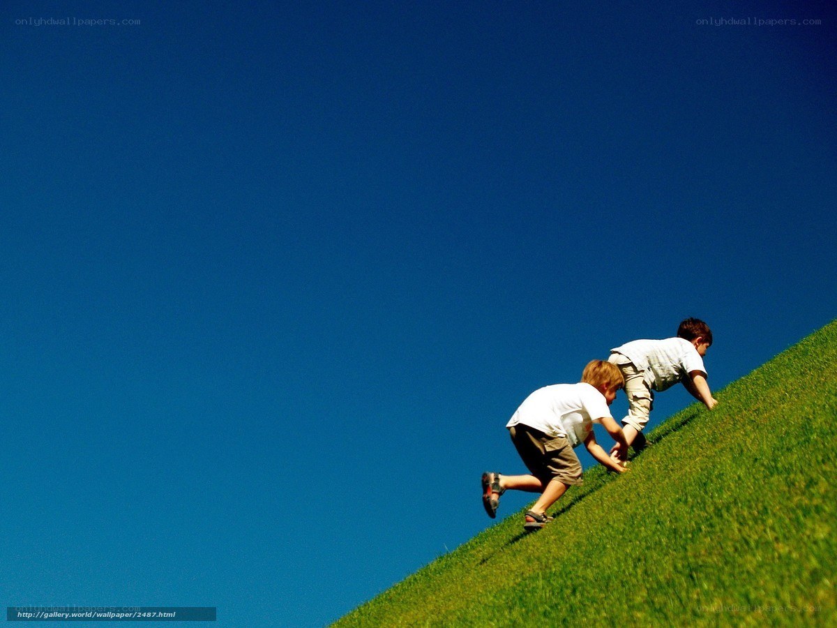 Children climbing a grassy hill