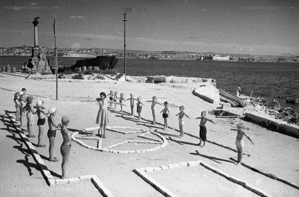 Children doing exercises by the sea