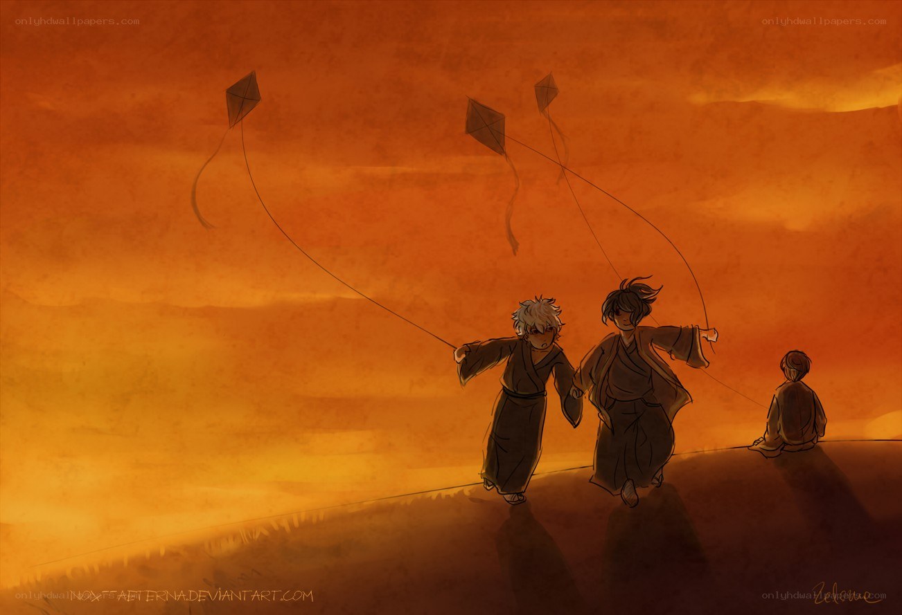 children flying kites at sunset