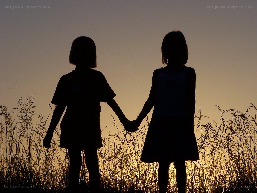 children holding hands at sunset