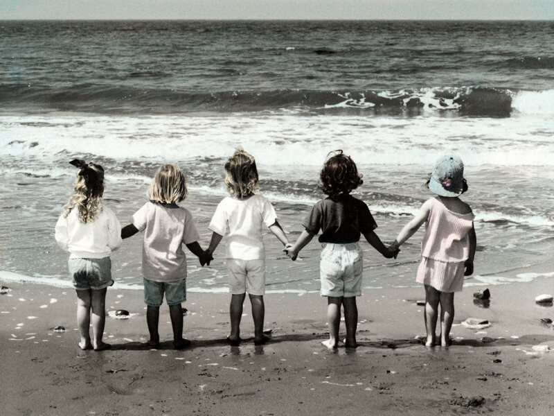 children holding hands at the beach