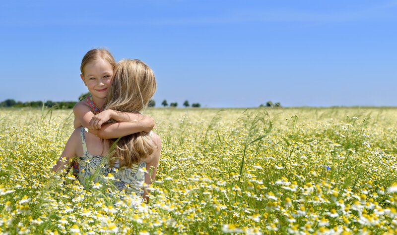 Children hugging in a flower field