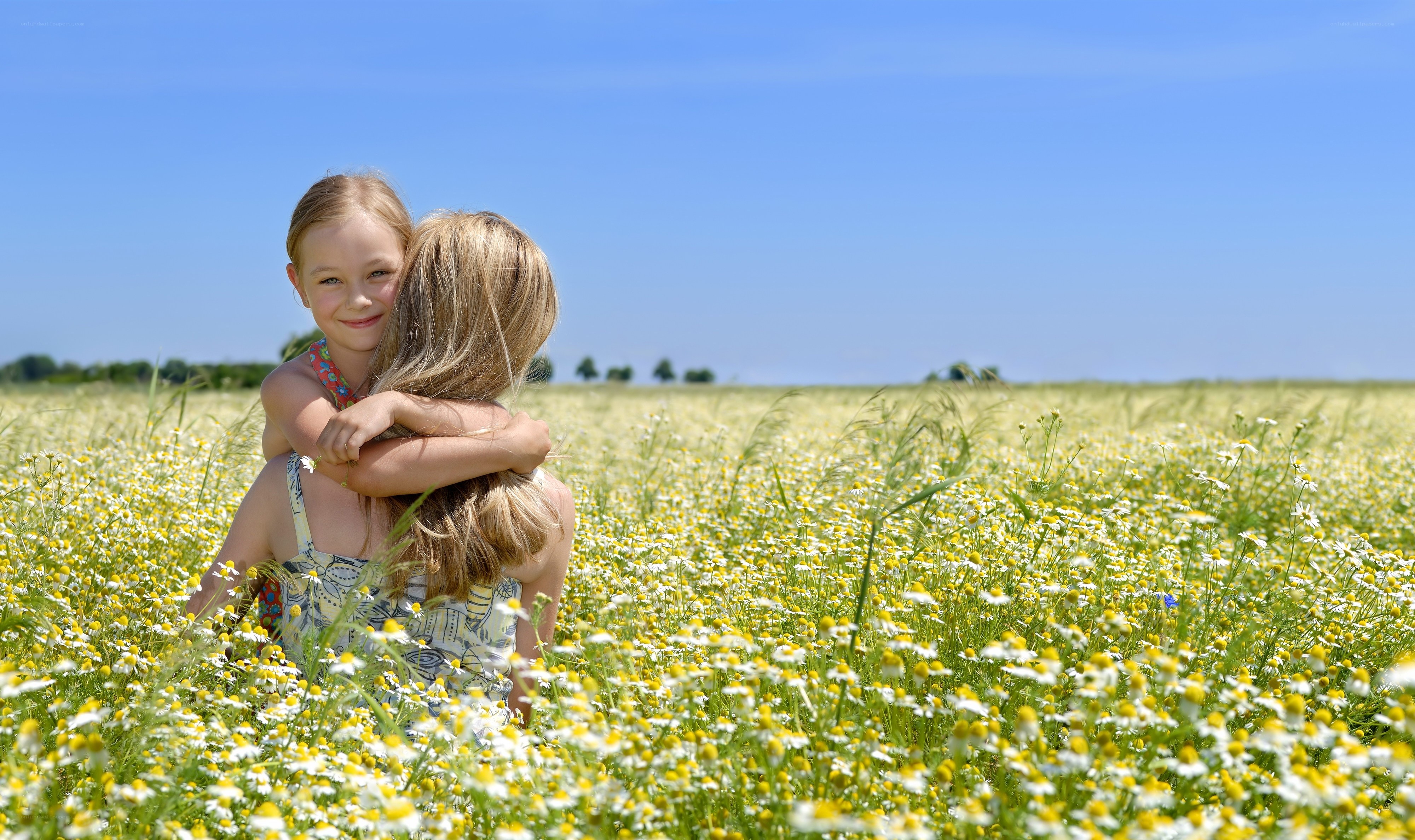 Children hugging in a flower field