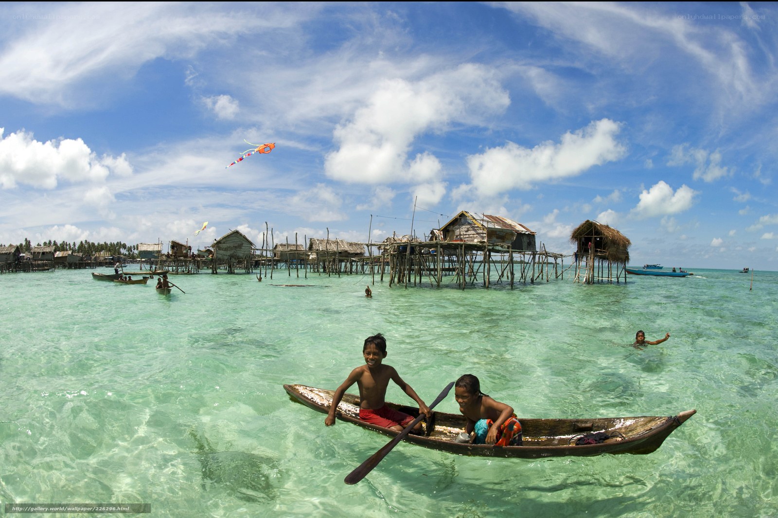 Children in a boat near stilt houses