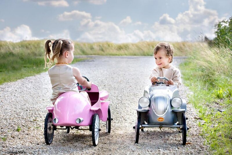 Children in toy cars on a path