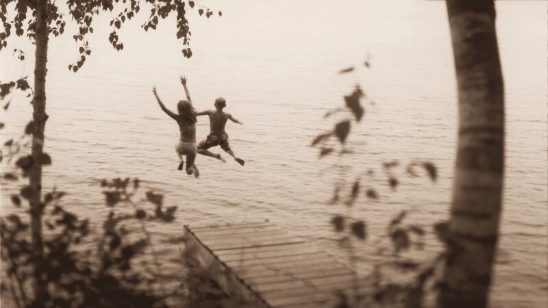 Children jumping into a lake