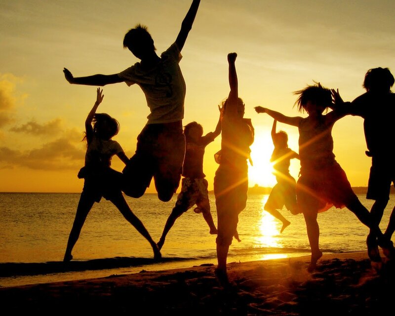 Children jumping on the beach at sunset