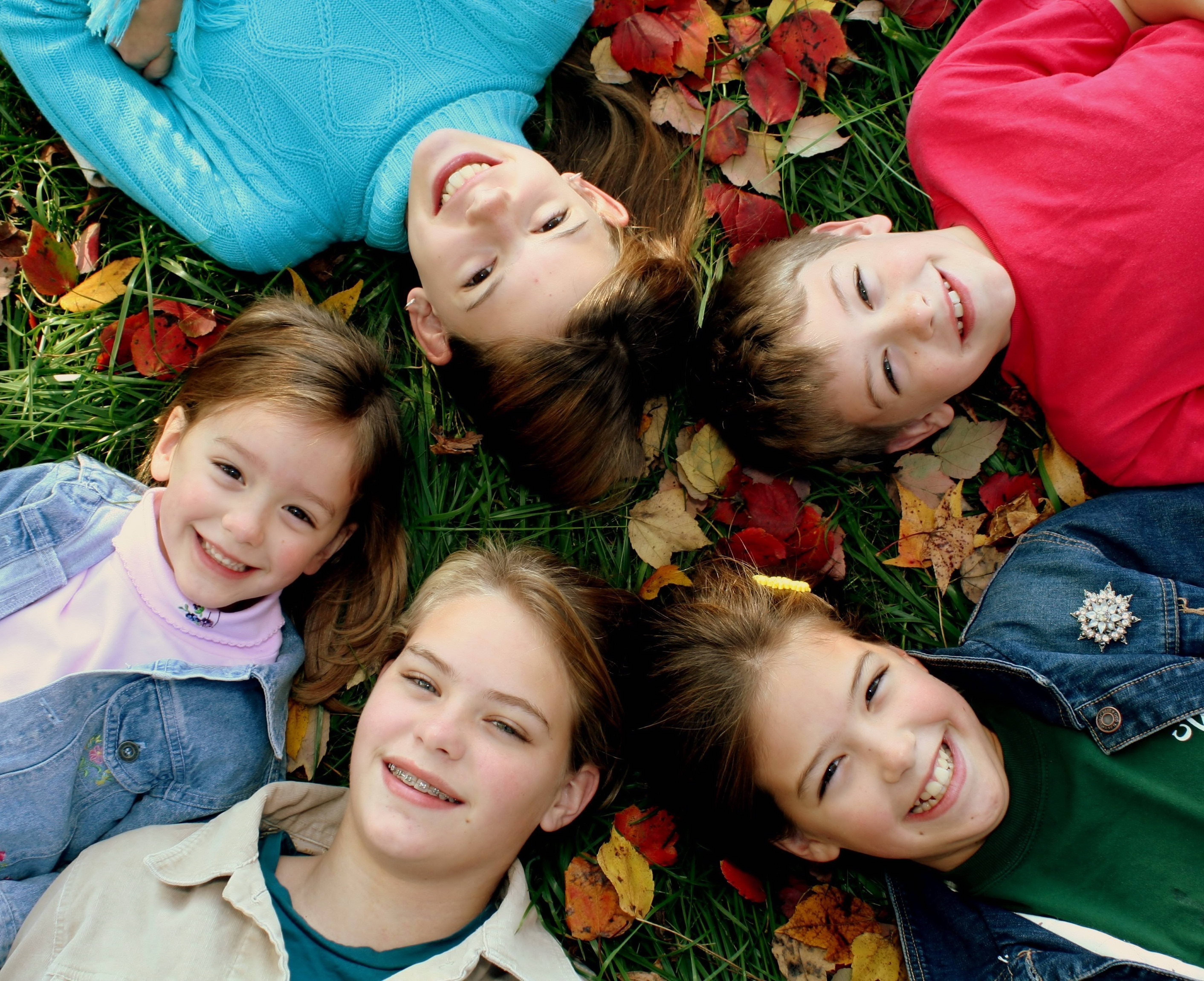 Children lying in autumn leaves