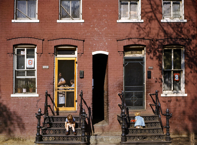 Children on brick house steps