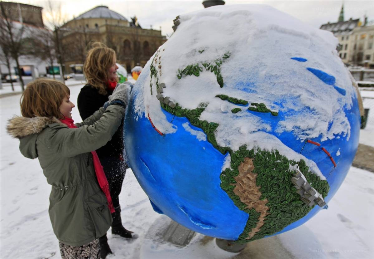 Children play with snow-covered globe