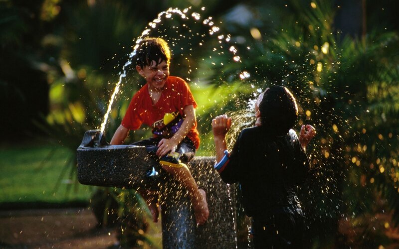 Children playing at a water fountain
