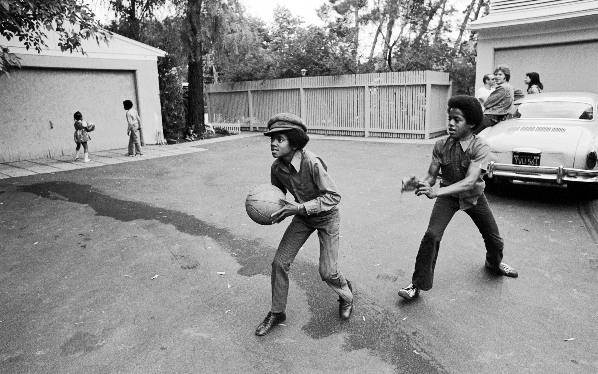Children playing basketball in driveway