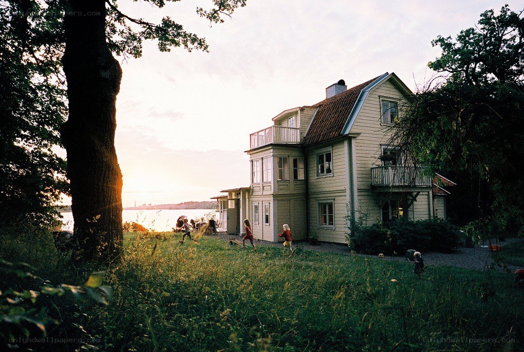 Children playing by a lakeside house
