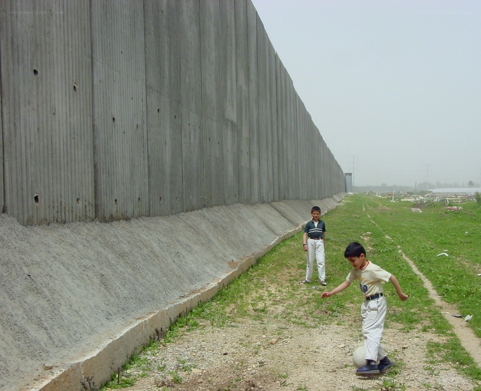 Children playing near a concrete wall