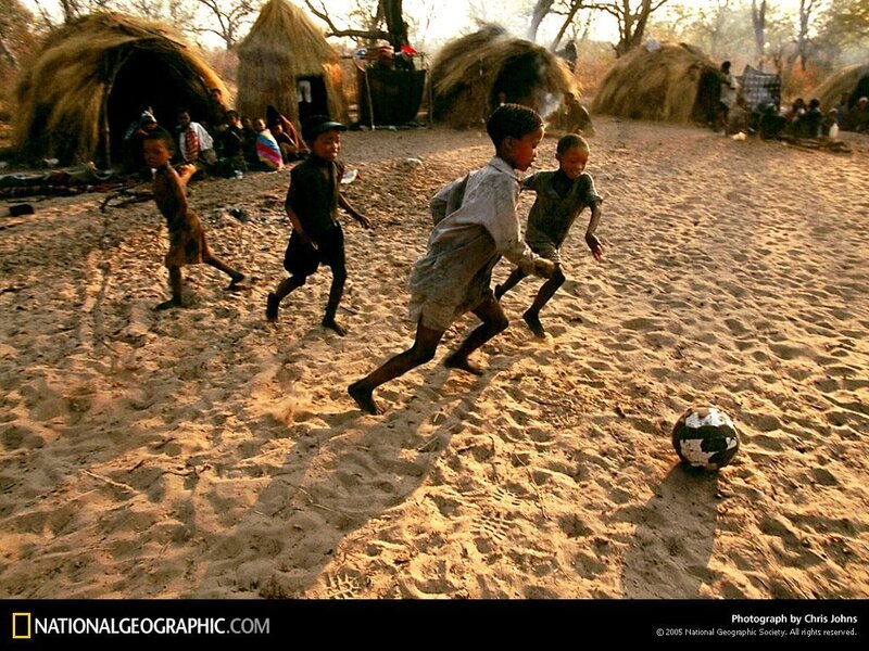Children playing soccer in village