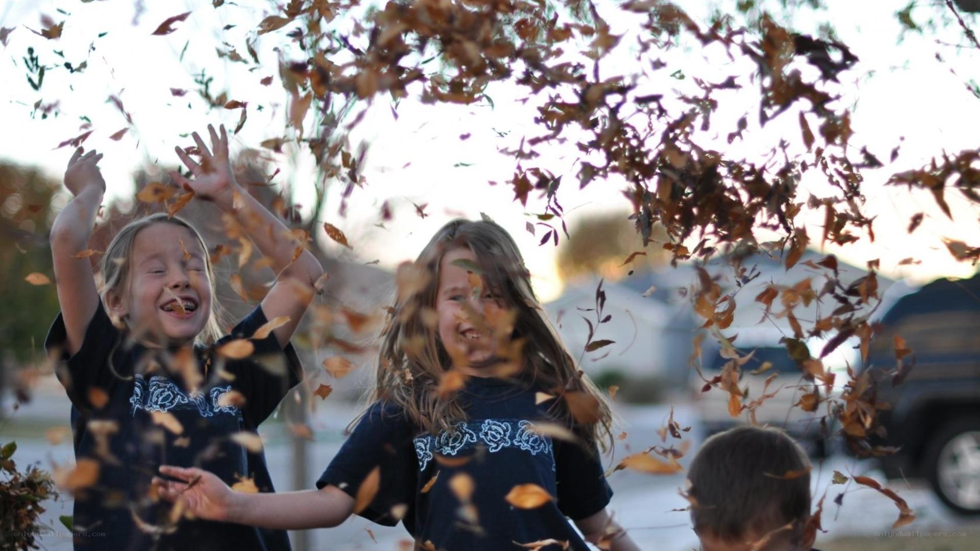 Children playing with autumn leaves