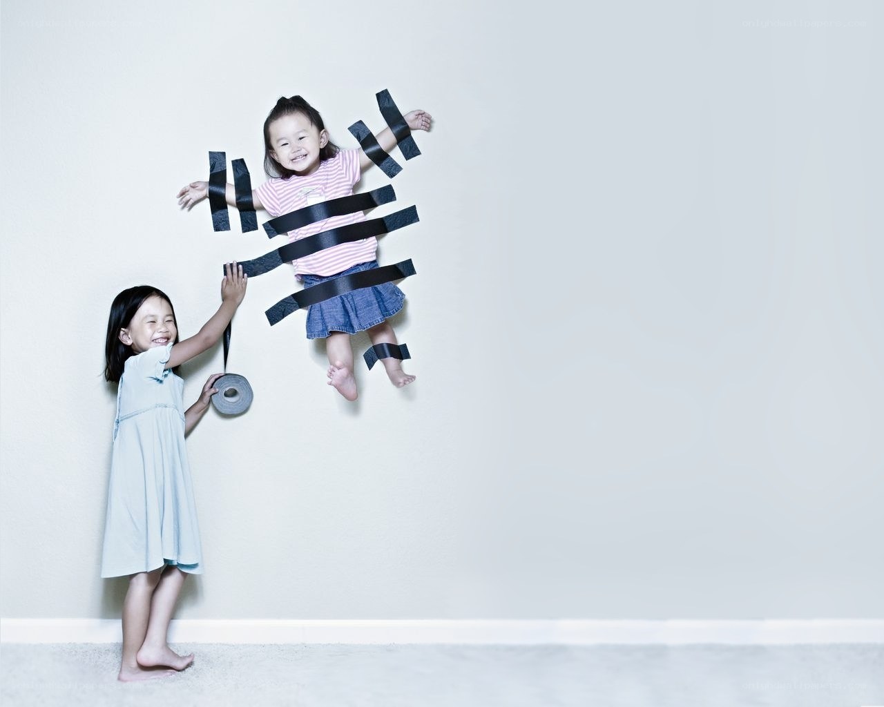 Children playing with tape on wall