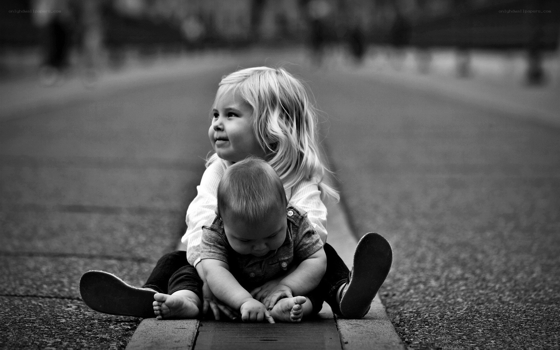 children sitting on pavement