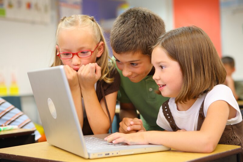 children using laptop in classroom