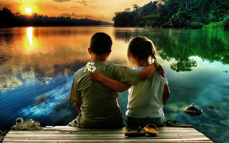 Children watching sunset by the lake