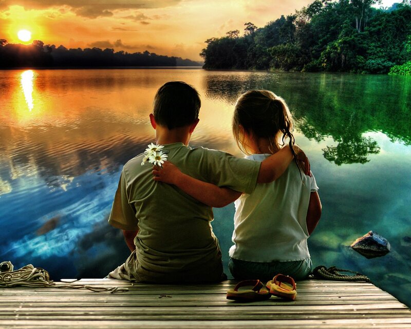 Children watching sunset by the lake
