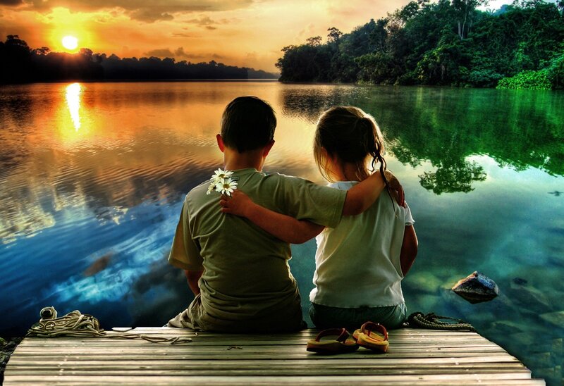 Children watching sunset by the lake