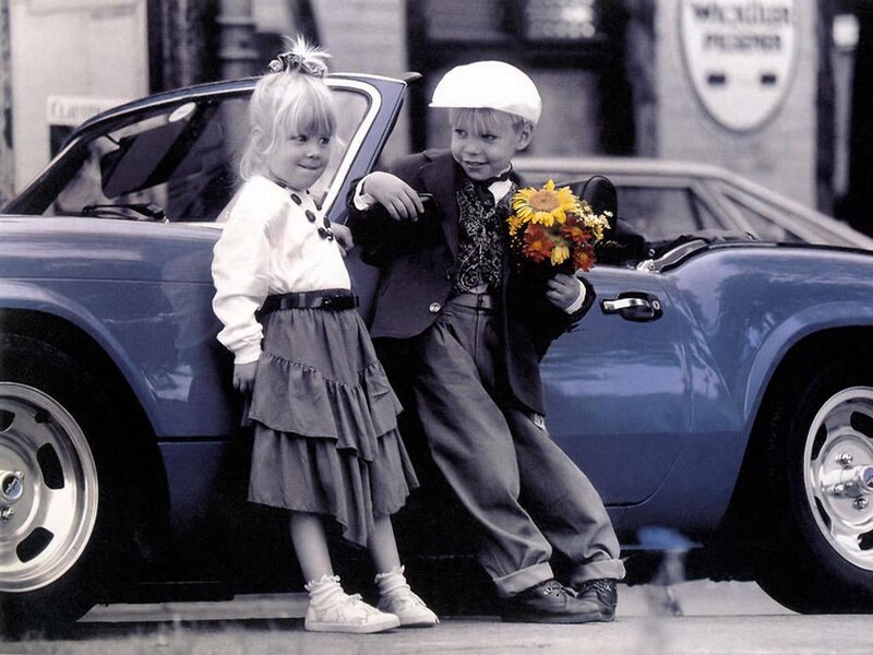 Children with flowers by a car