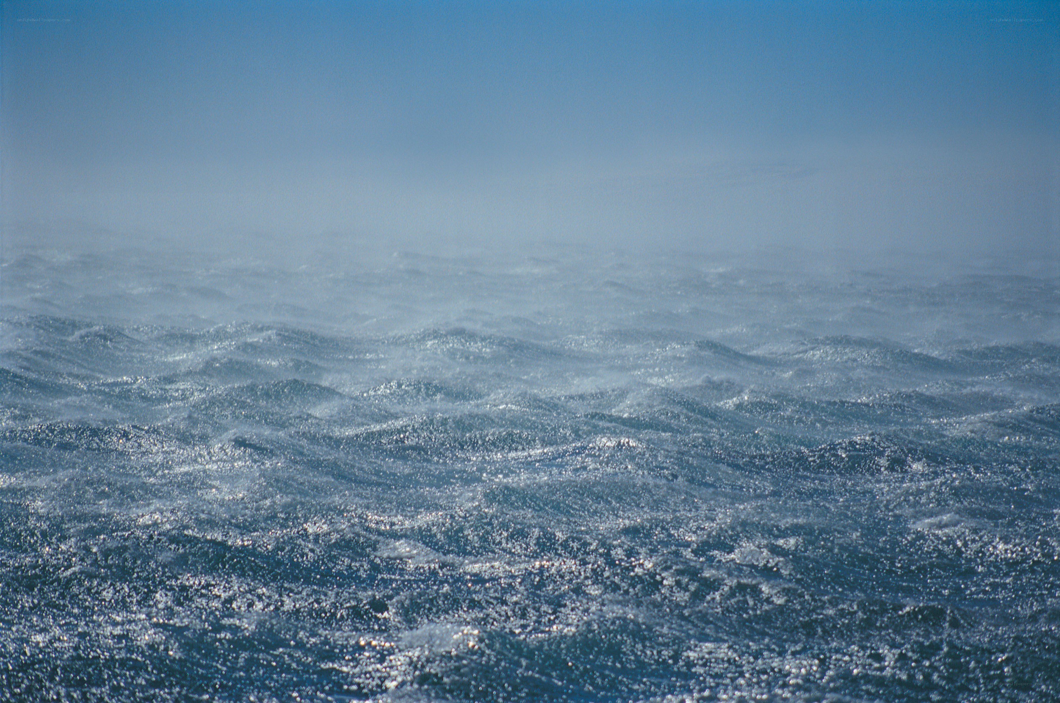 Choppy ocean waves under blue sky