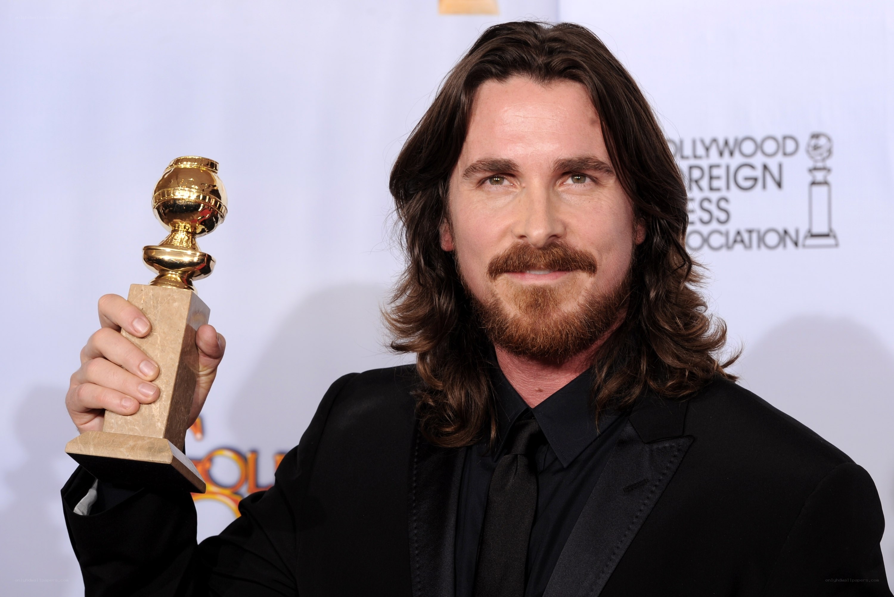 Christian Bale holding Golden Globe