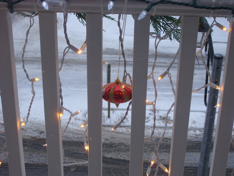 Christmas lights on a snowy porch