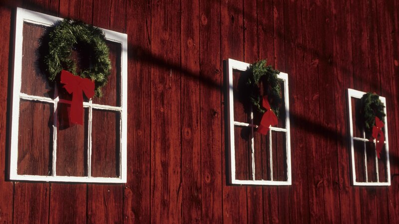 Christmas wreaths on red barn