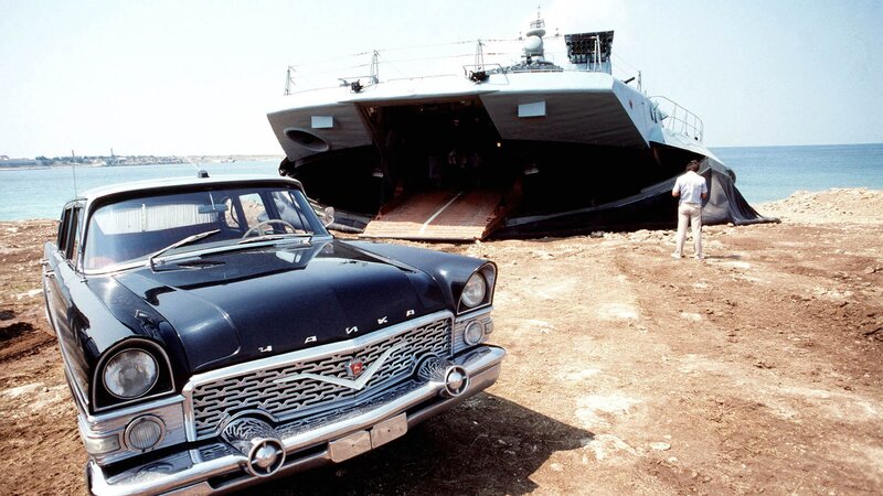 Chrysler car on beach near boat