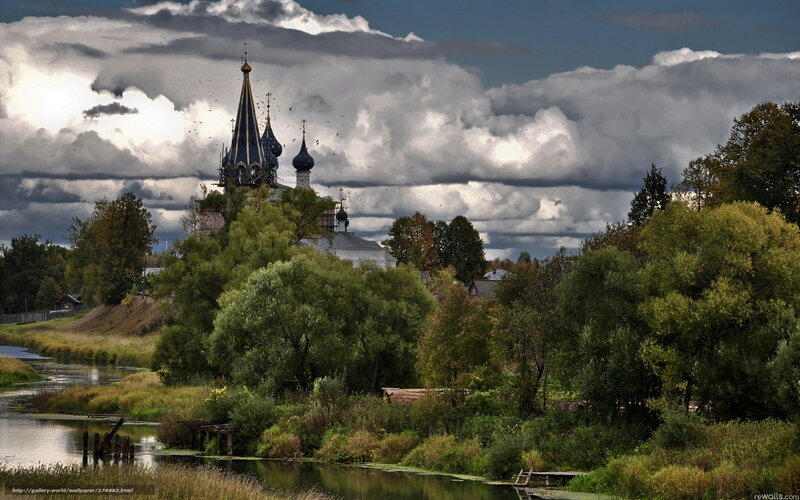 Church by the river under stormy sky