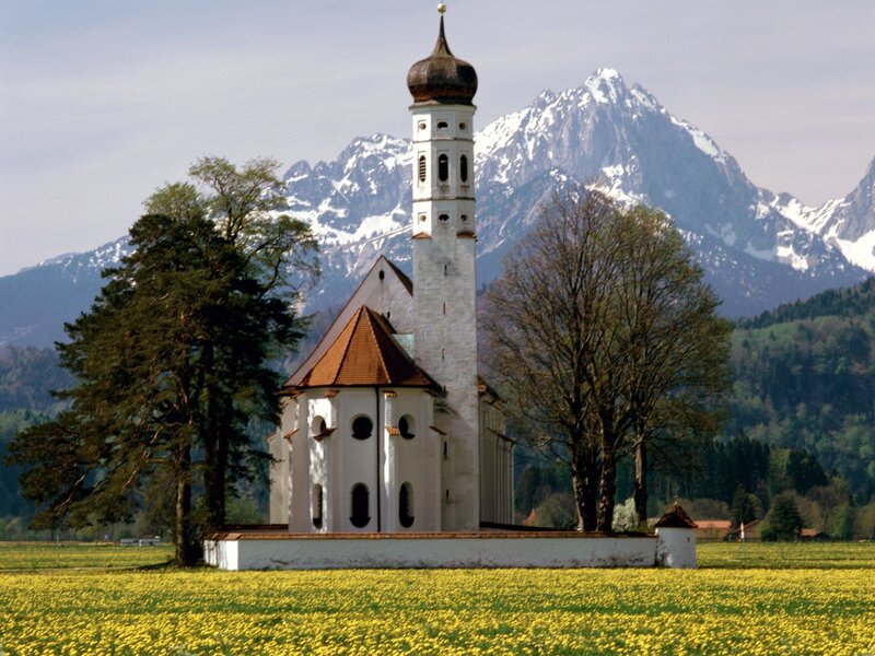 Church in a yellow field with mountains