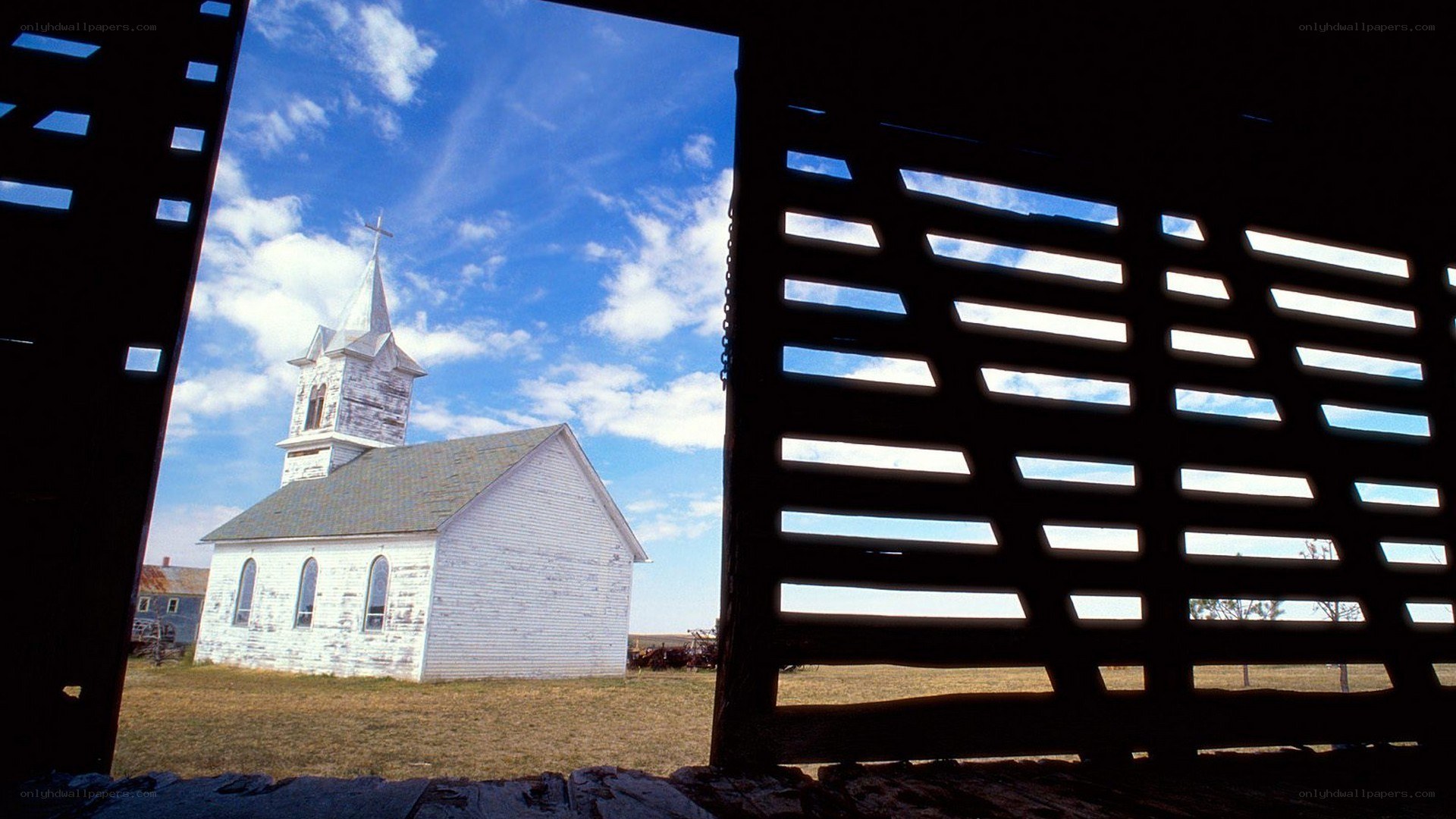 Church seen through barn slats