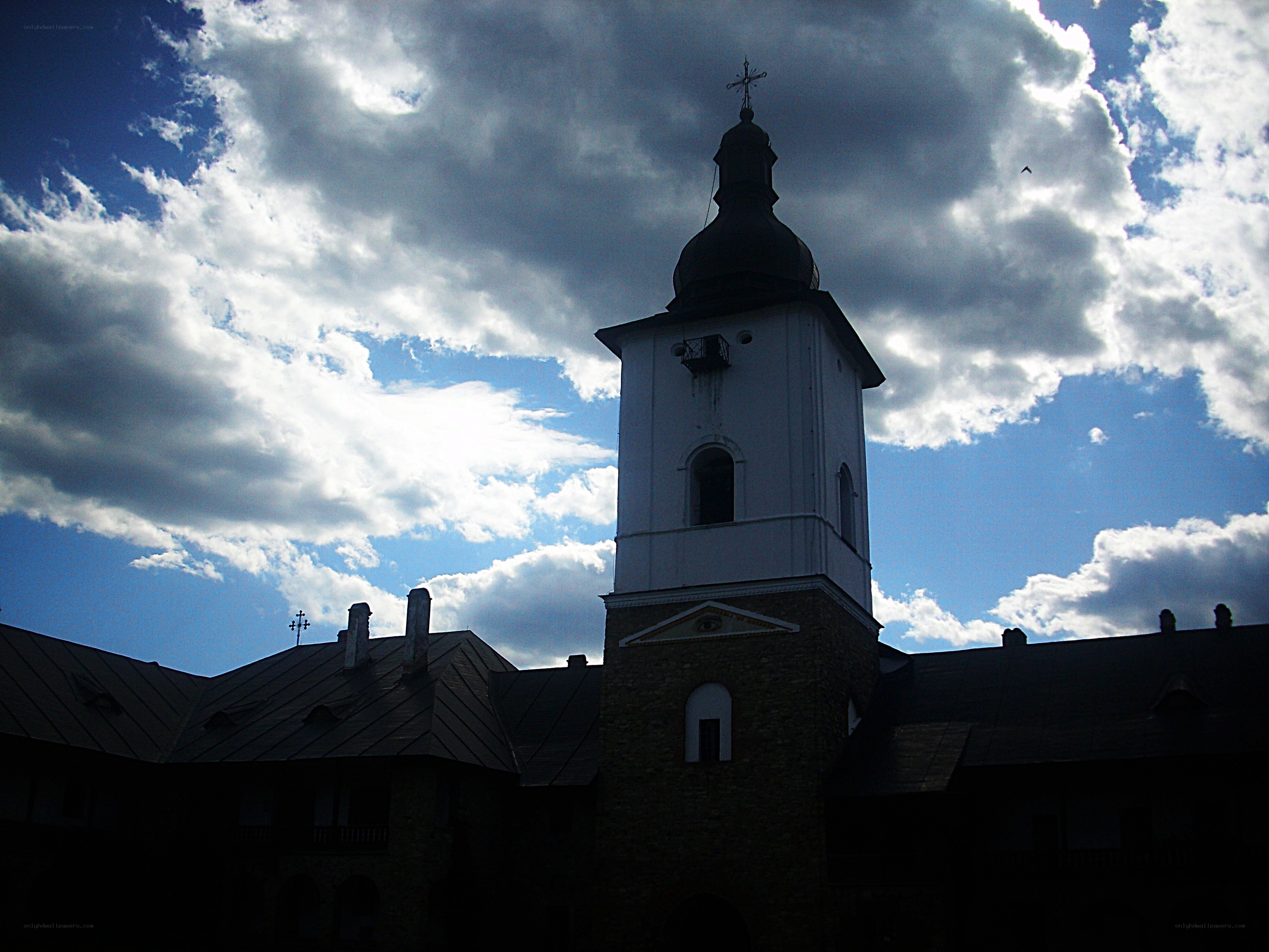 Church tower against cloudy sky