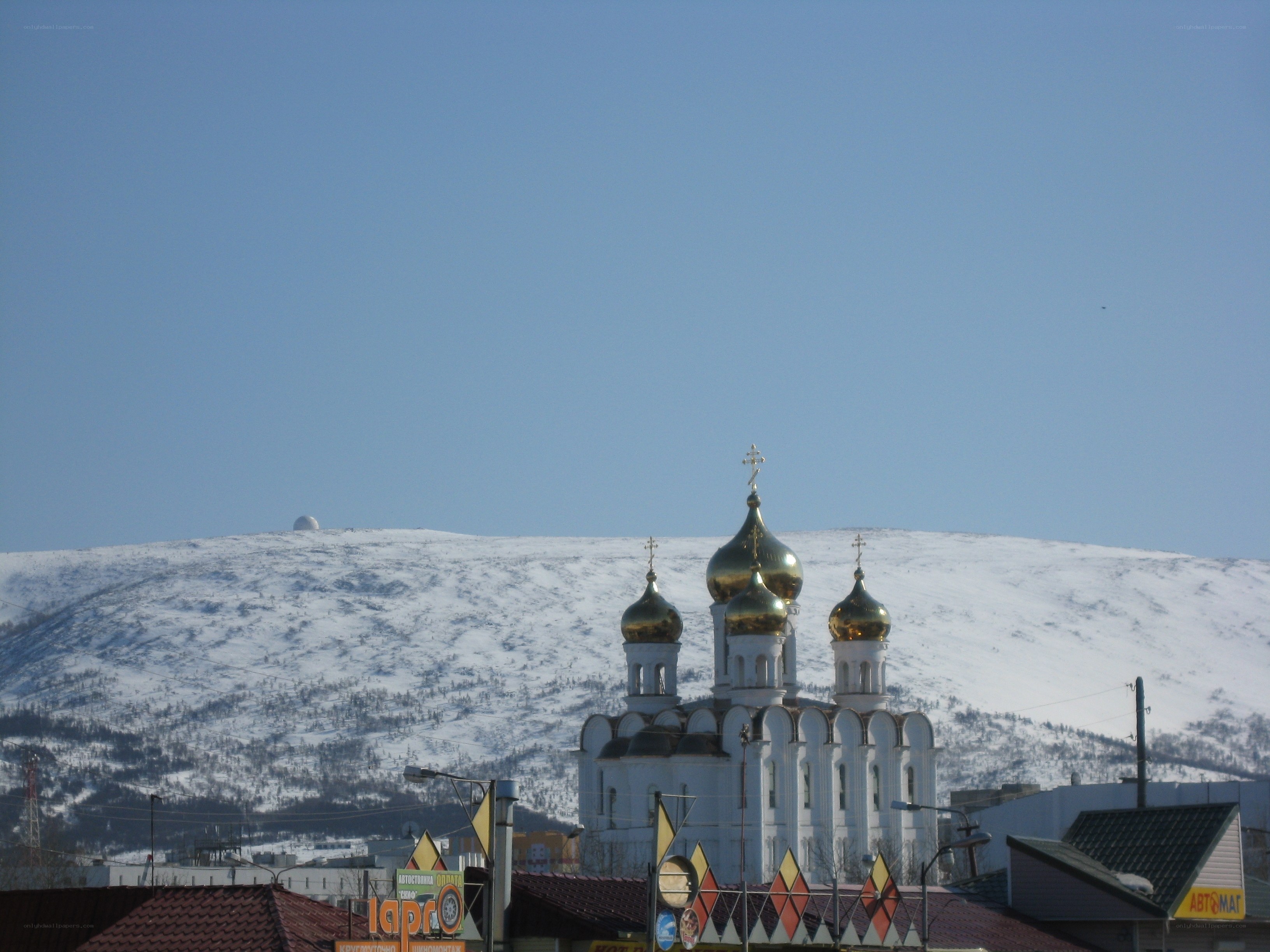 Church with golden domes in snowy landscape