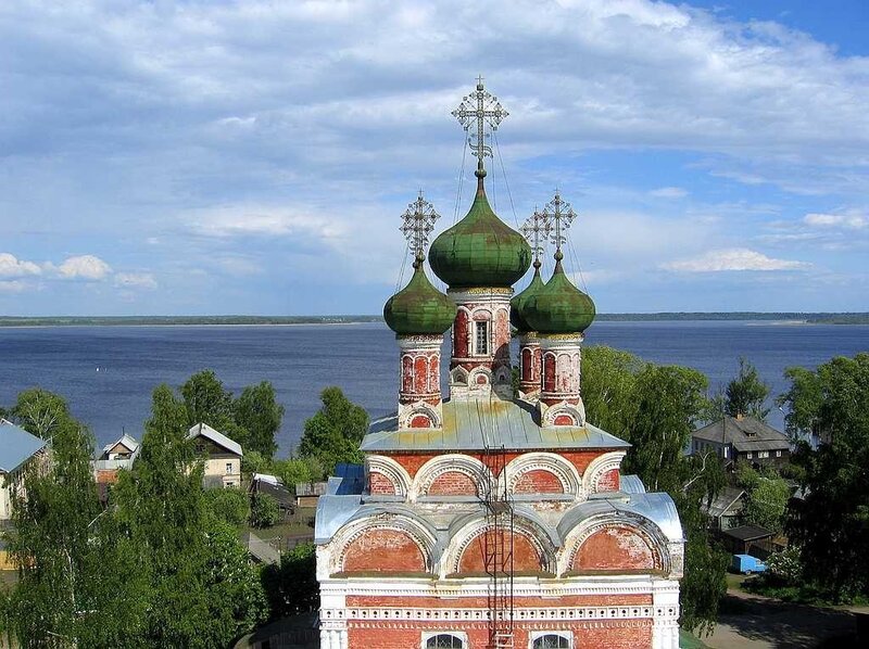 Church with green domes by a river
