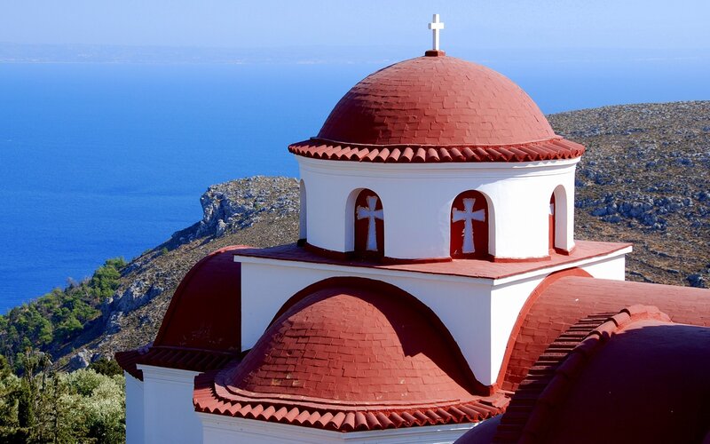 Church with red domes by the sea