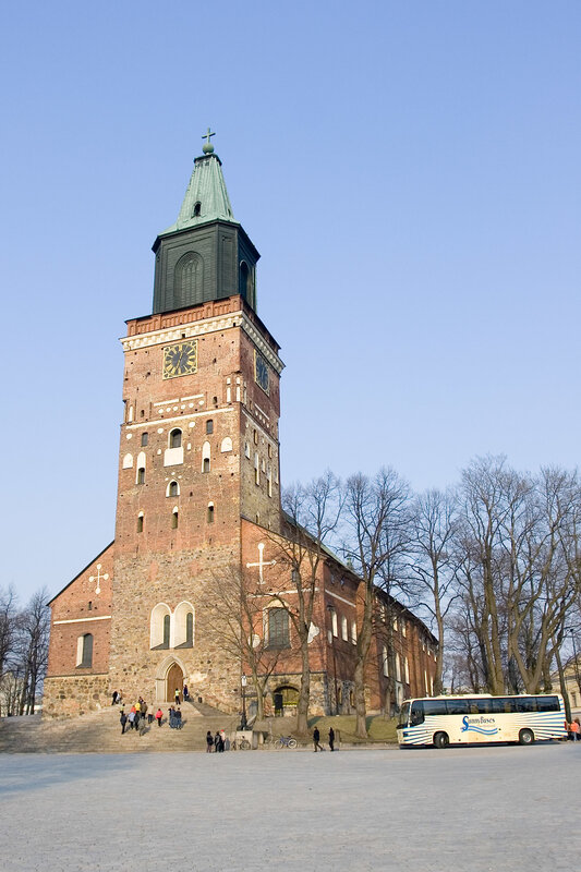 Church with tall tower and bus