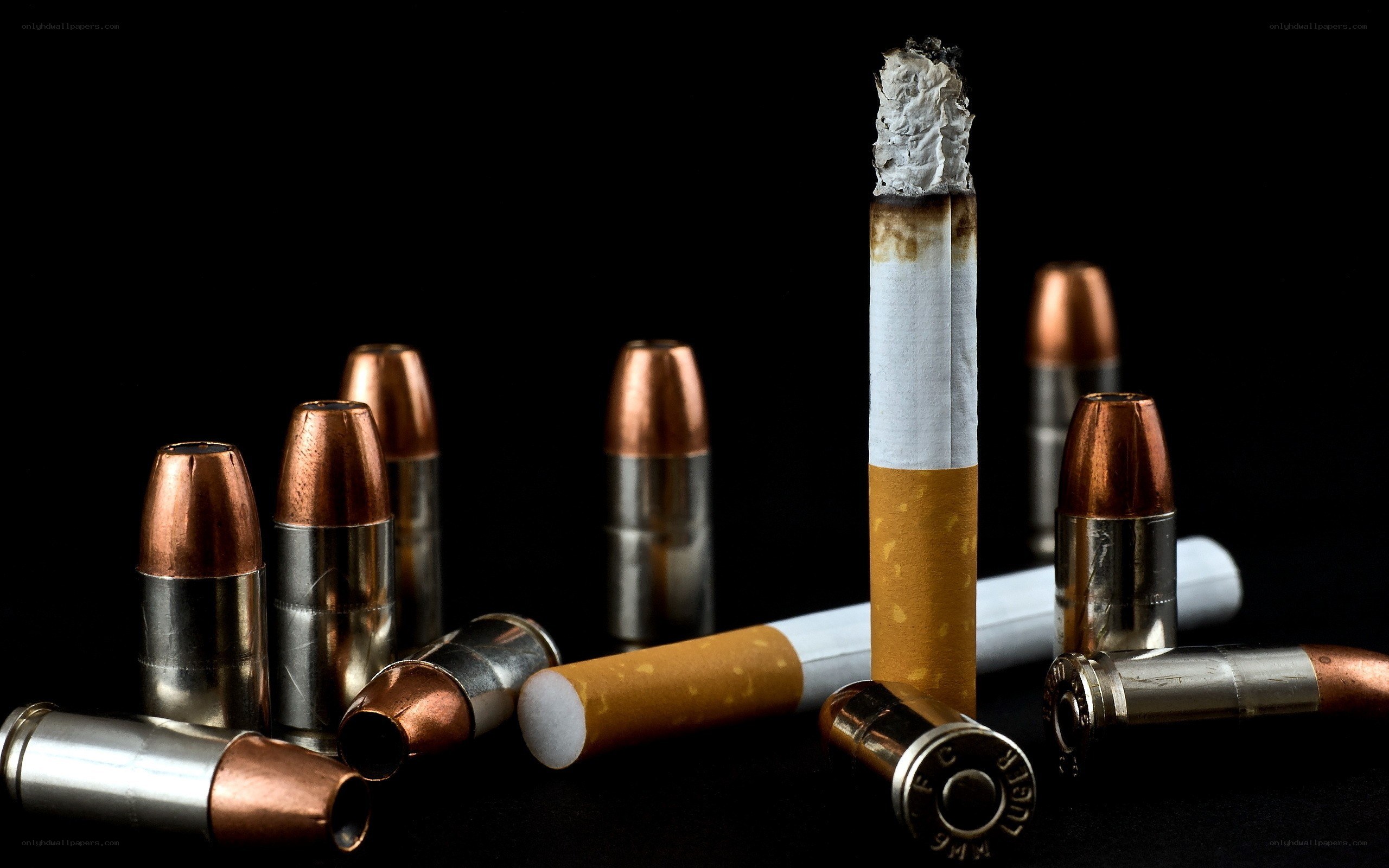 Cigarette and bullets on black