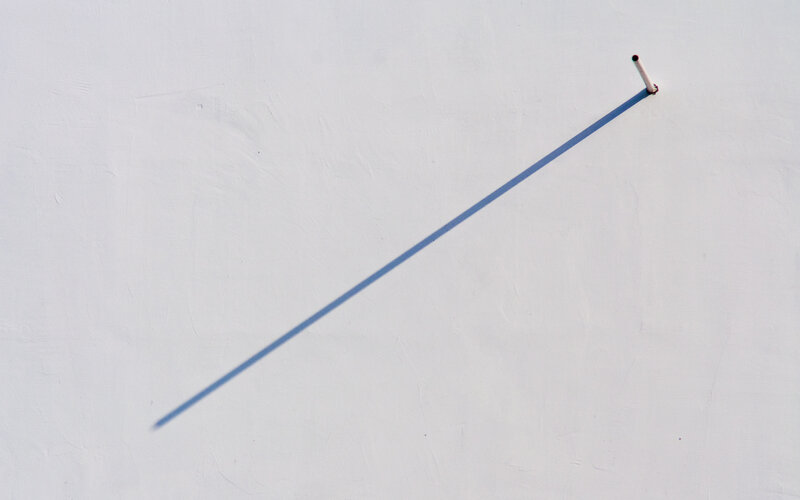 cigarette and shadow on white wall