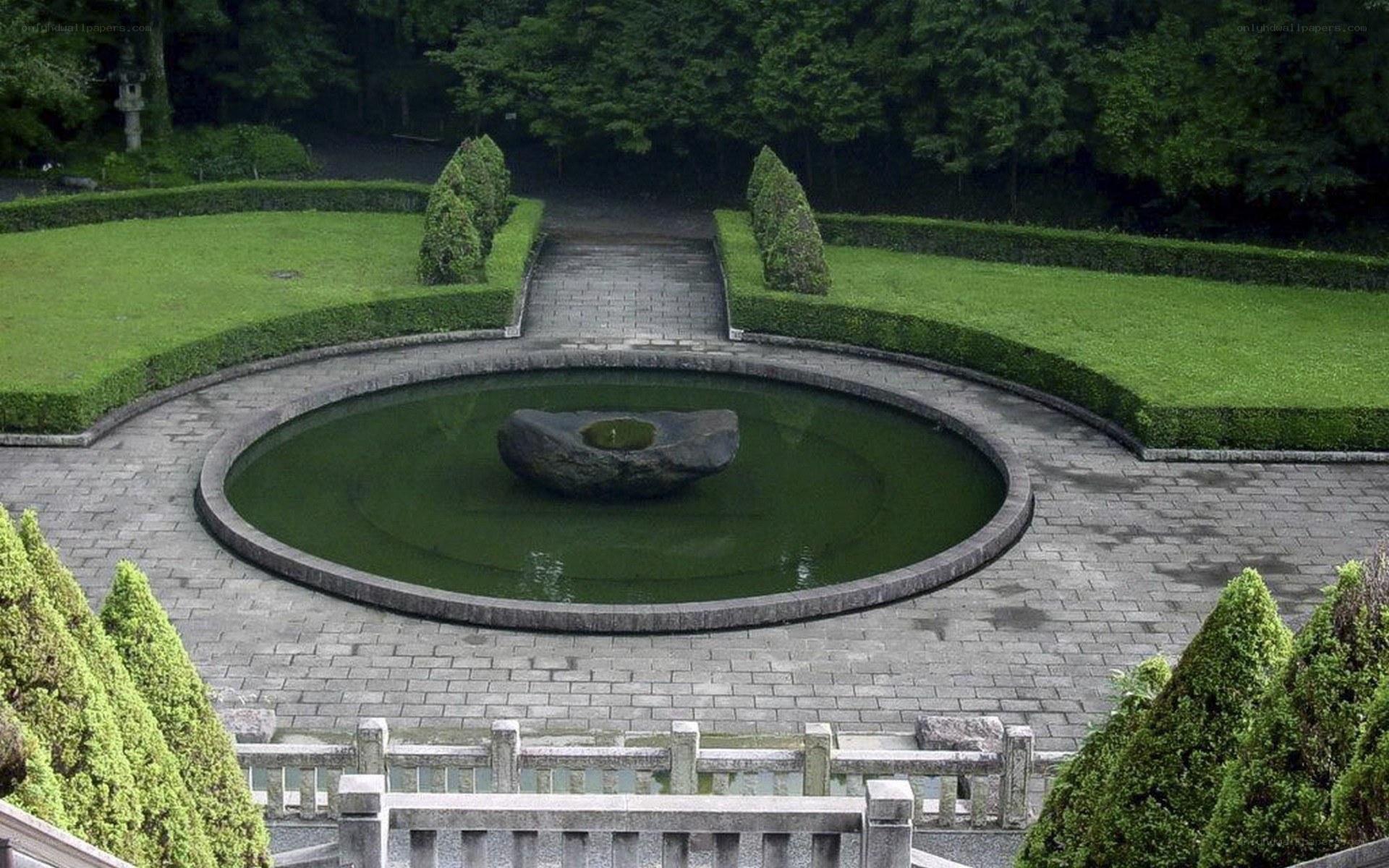 Circular garden pond with stone