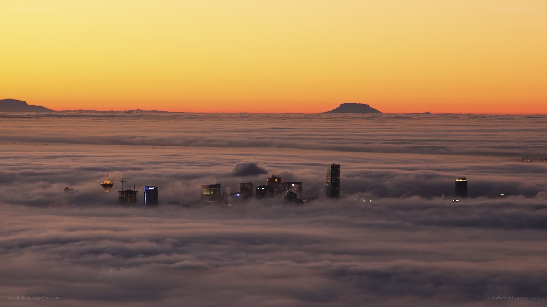 City above the clouds at sunset
