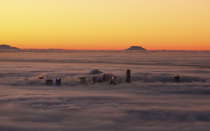 City above the clouds at sunset