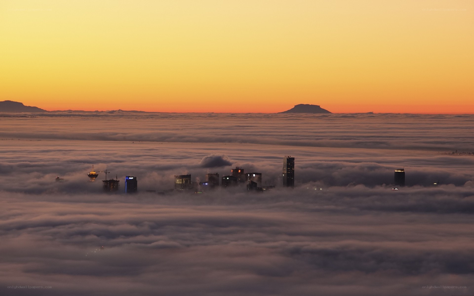 City above the clouds at sunset