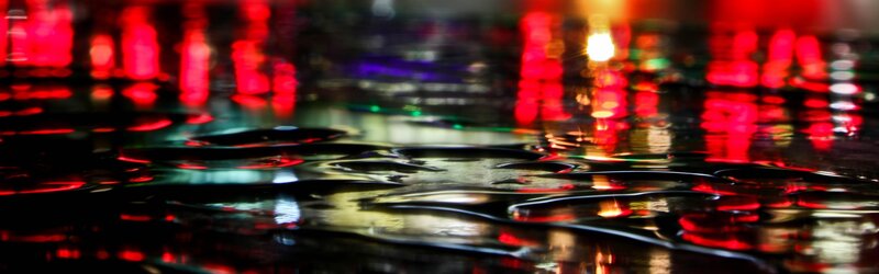 City lights reflecting on wet pavement