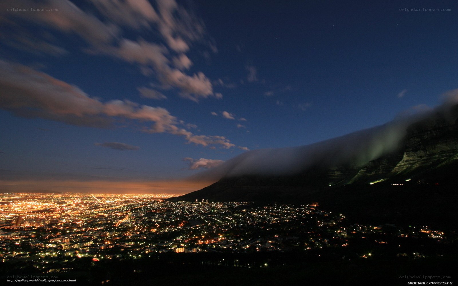 City lights under mountain clouds